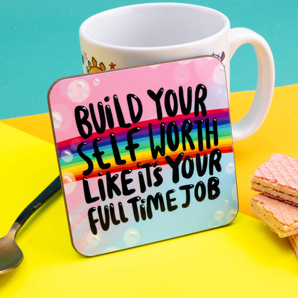 A Katie Abey illustrated coaster on a pastel blue and pink bubbly background with a rainbow running through. Over the top text says, Build your self worth likes its your full time job