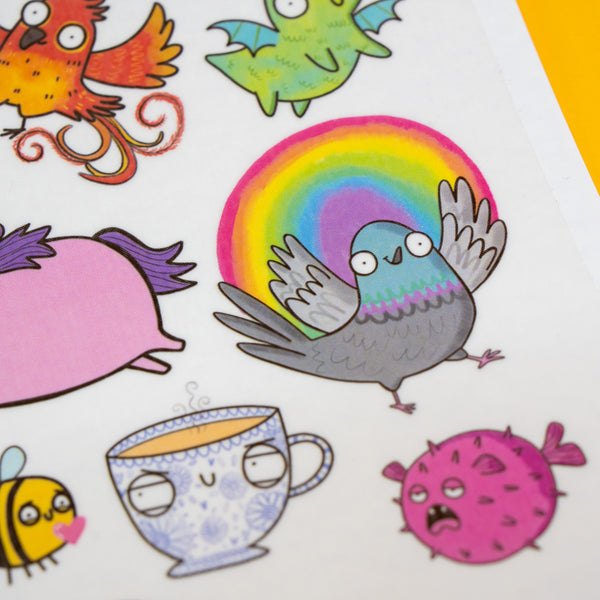 Detailed view of Katie Abey temporary tattoo sheet featuring a rainbow pigeon, grumpy pufferfish and patterned teacup character, showcasing bright colours and fun, expressive illustrations.
