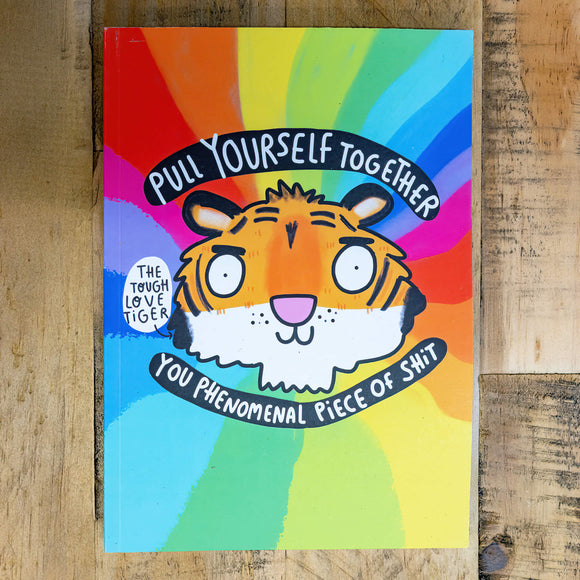 A notebook with a rainbow backdrop and an illustration by Katie Abey of a Tigers Head with Pull yourself together you phenomenal piece of shit, with a speech bubble saying The Tough Love Tiger