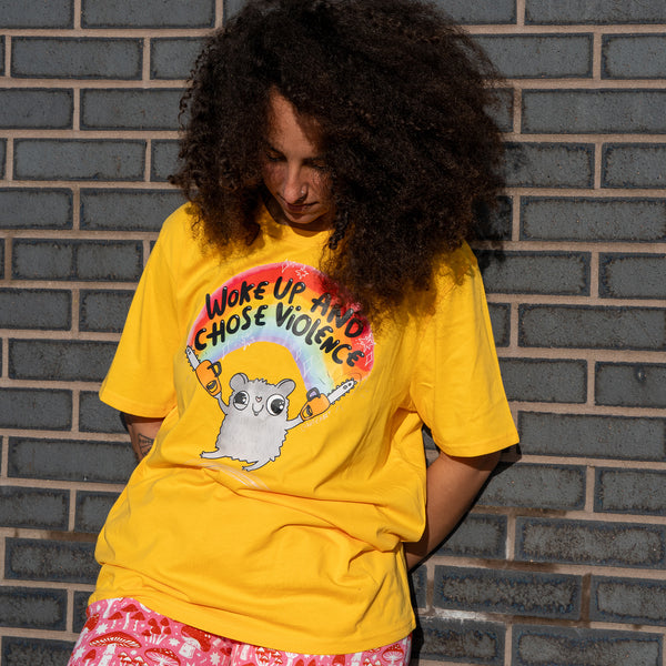 Front angled view of the Woke Up and Chose Violence Hamster Adults Tee in Spectra Yellow by Katie Abey. The playful hamster and rainbow graphic stands out against the yellow fabric. Comfortable adult t shirt with a fun illustrated slogan, designed by UK illustrator Katie Abey who encourages embracing your weirdness.
