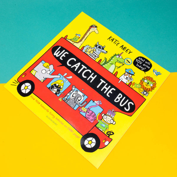 We catch the bus by Katie Abey book. The book cover is a yellow base featuring various fun animals wearing hats on and atop a red double decker bus with a banner that reads 'We catch the bus'. There's a speech bubble reading 'what will YOU drive today?' and bottom text reads 'find YOUR favourite vehicles on EVERY page'. Printed in the UK by bloomsbury.