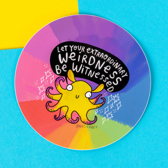 A vibrant sticker by Katie Abey featuring a yellow octopus with a quirky expression, surrounded by a colourful rainbow gradient background. The text reads, "Let your extraordinary weirdness be witnessed." The design encourages embracing uniqueness and stands out against a background of blue and yellow. Ideal for adding a touch of whimsy to personal items. Katie Abey's art celebrates individuality and positivity.