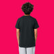 Back view of black kids t shirt by Katie Abey, plain design showing relaxed fit and short sleeves. Organic cotton children’s tee photographed on a bright pink background, showcasing the simple back and comfortable everyday wear for kids.