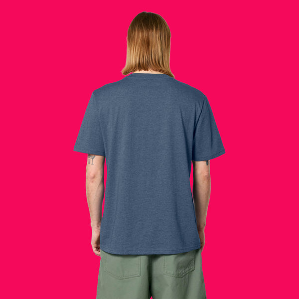 Back view of a model wearing the Wield Your Weird Adults T Shirt by Katie Abey in dark heather blue. The relaxed fit short sleeve T shirt is styled casually with green trousers on a bright pink background.