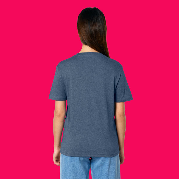 Back view of a model wearing the Wield Your Weird Adults T Shirt by Katie Abey in dark heather blue. The unisex fit T shirt is shown from behind with light blue jeans against a bright pink background.