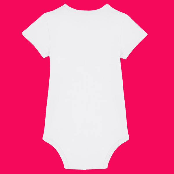 White organic cotton babygrow shown from the back against a bright pink background. Short sleeved baby bodysuit with a smooth plain back, soft rib binding at the neckline and leg openings, and snap fastenings at the bottom for easy changes. Unisex baby clothing suitable for everyday wear.
