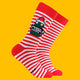 Red and white striped Christmas socks featuring Katie Abey’s Sweary Cat character holding a sign that reads “Merry F*cking Xmas”. The socks have red heels and toes, with a fun festive design against a bright yellow background. Quirky Christmas novelty socks from small UK illustrator Katie Abey.