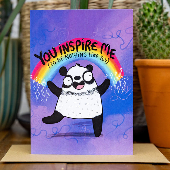 Purple greeting card with panda and rainbow illustration with the words 'you inspire me (to be nothing like you)' written on.