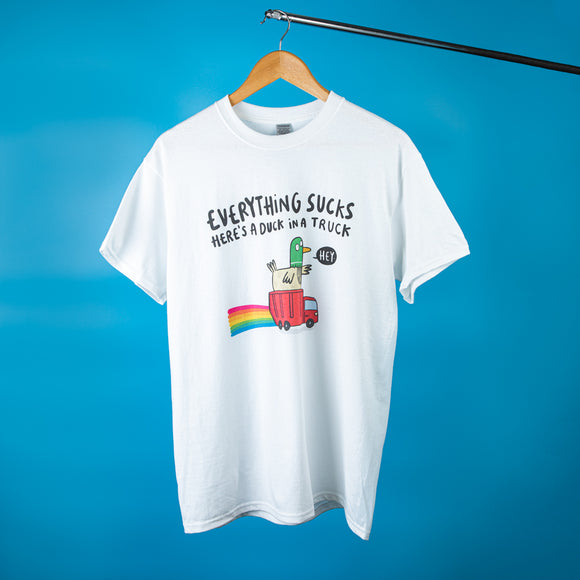 Everything Sucks Here's A Duck in a Truck black writing on a white cotton tshirt, featuring a waving green duck sitting in a red truck with rainbows illustration. Designed by Katie Abey in the UK.