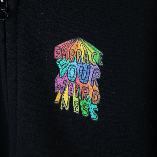 Kids childrens size black hoodie jumper with hood reading 'Embrace Your Weirdness' printed in bold large colourful rainbow letters on the back, and small on the front right hand side, in red orange yellow green teal blue purple and pink. Also has front zip and large pocket. Designed by Katie Abey in the UK.
