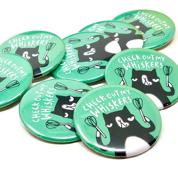 Check out my whiskers cat badge. Black and white cat holding whisks on green teal background. Designed by Katie Abey in the UK