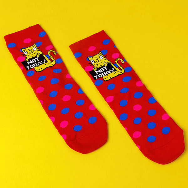 Not Today Knitted Red Kids Socks with blue and pink polka dots and yellow smiley cat holding sign. Designed by Katie Abey in the UK 