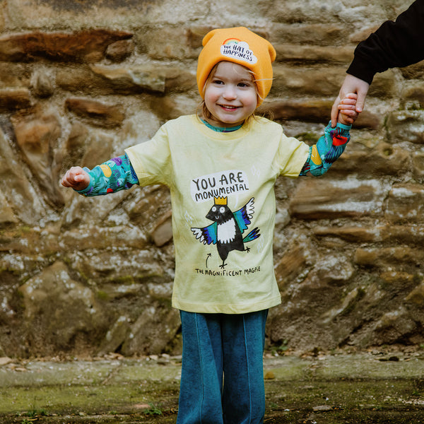 Monumental Magpie Yellow Kids Tshirt 100% cotton tshirt with illustrated happy magpie design wearing crown with speech bubble and black writing that reads 'The Magnificent Magpie'. Designed in the UK by Katie Abey